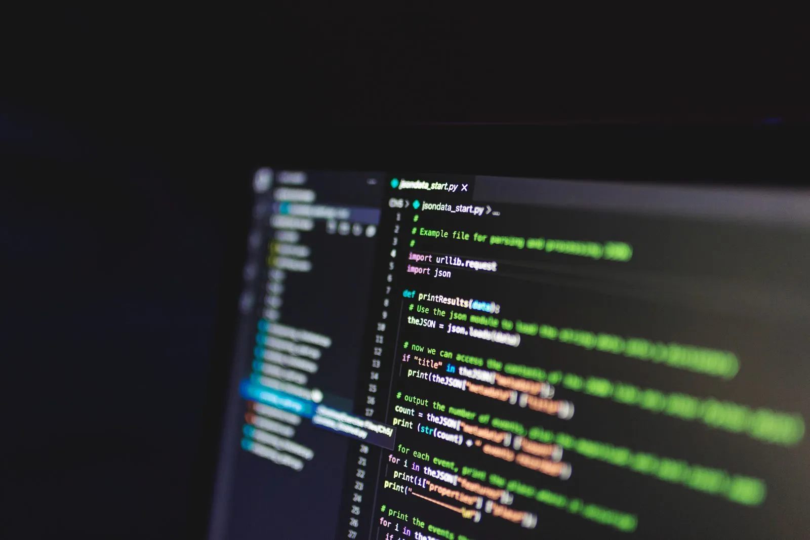Blurred code editor screen showing a Python script for parsing JSON data