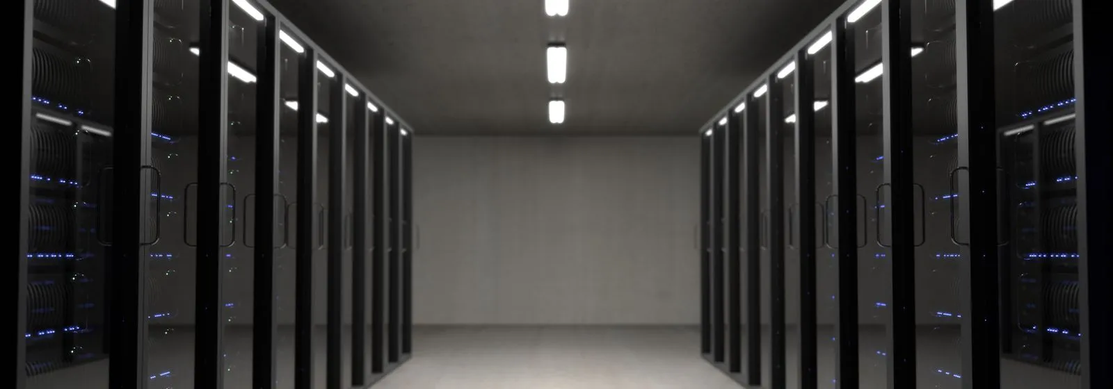 Dim data center corridor lined with server racks glowing under overhead lights