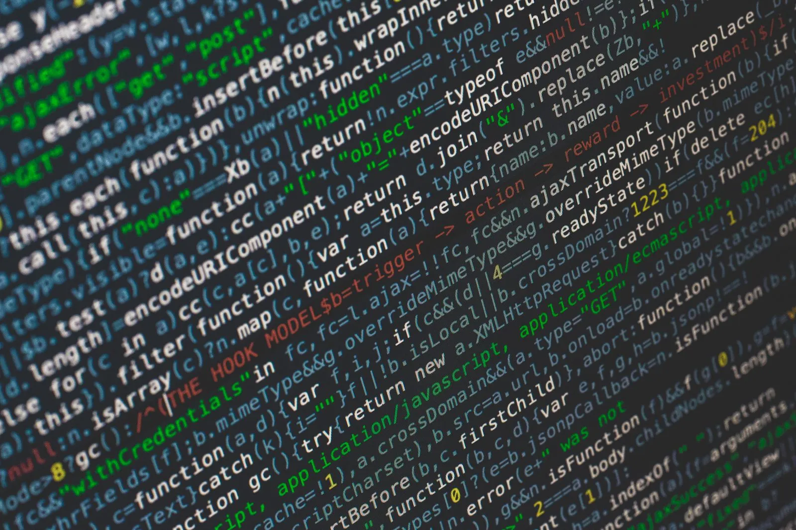 Angled close-up of a screen showing minified jQuery source code with ajax functions