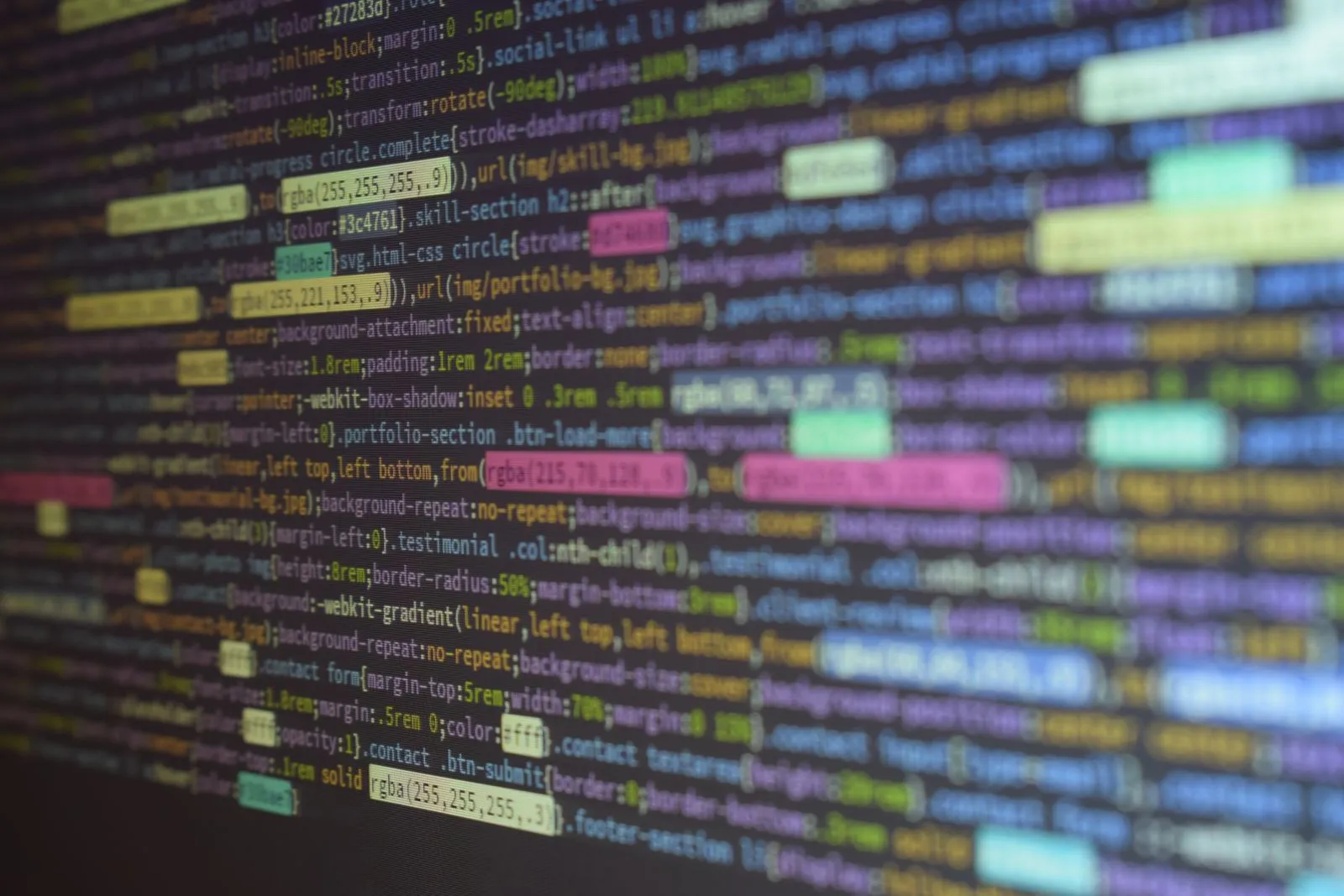 Blurred close-up of CSS stylesheet code defining portfolio and testimonial sections