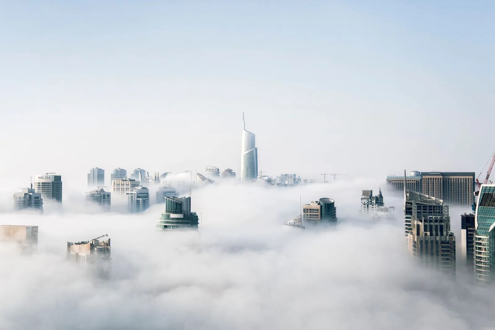 City skyscrapers rising above a thick blanket of morning fog