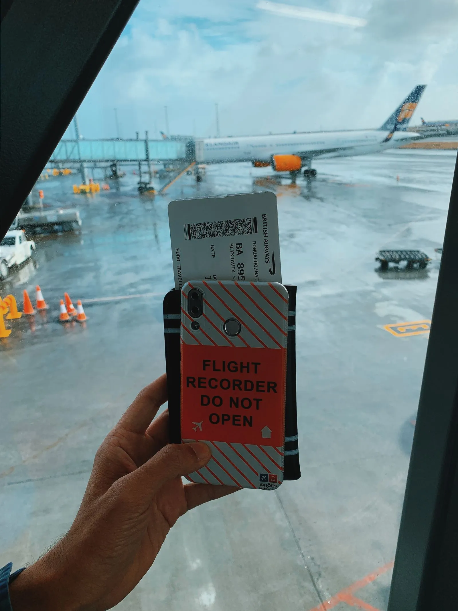 Traveler holding a smartphone and boarding pass at an airport